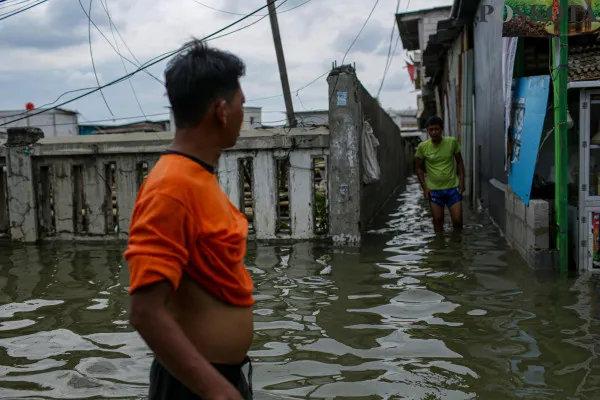 Aktivitas warga saat melintasi banjir rob di pemukiman padat penduduk Muara Angke, Jakarta Utara, Minggu, 15 Desember 2024. (Poskota/ Ahmad Tri Hawaari)