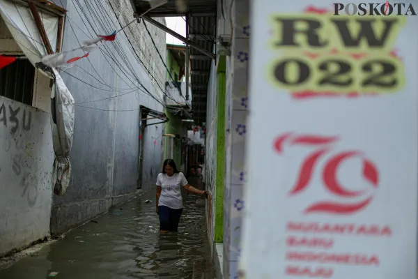 Aktivitas warga saat melintasi banjir rob di pemukiman padat penduduk Muara Angke, Jakarta Utara, Minggu, 15 Desember 2024. (Poskota/ Ahmad Tri Hawaari)