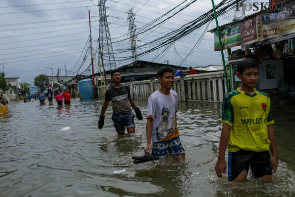 Aktivitas warga saat melintasi banjir rob di pemukiman padat penduduk Muara Angke, Jakarta Utara, Minggu, 15 Desember 2024. (Poskota/ Ahmad Tri Hawaari)