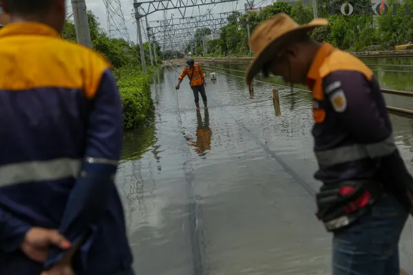 Sejumlah kendaraan saat menerobos banjir rob dan petugas rel kereta api saat mengecek ketinggian air di kawasan Jakarta Internasional Stadium (JIS), Jalan R.E.Martadinata, Jakarta Utara, Minggu, 15 Desember 2024. (Poskota/ Ahmad Tri Hawaari)
