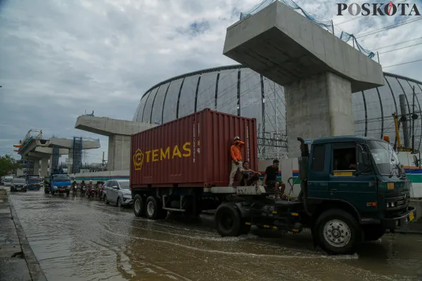 Sejumlah kendaraan saat menerobos banjir rob dan petugas rel kereta api saat mengecek ketinggian air di kawasan Jakarta Internasional Stadium (JIS), Jalan R.E.Martadinata, Jakarta Utara, Minggu, 15 Desember 2024. (Poskota/ Ahmad Tri Hawaari)
