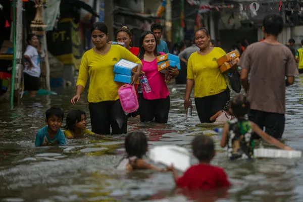 Aktivitas warga saat melintasi banjir rob di pemukiman padat penduduk Muara Angke, Jakarta Utara, Minggu, 15 Desember 2024. (Poskota/ Ahmad Tri Hawaari)