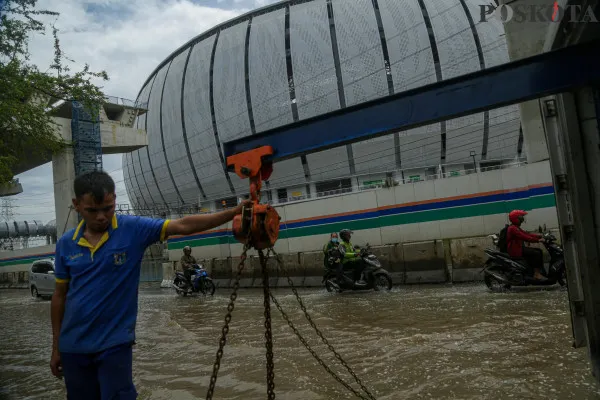 Sejumlah kendaraan saat menerobos banjir rob dan petugas rel kereta api saat mengecek ketinggian air di kawasan Jakarta Internasional Stadium (JIS), Jalan R.E.Martadinata, Jakarta Utara, Minggu, 15 Desember 2024. (Poskota/ Ahmad Tri Hawaari)