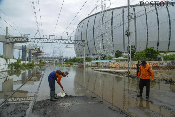 Sejumlah kendaraan saat menerobos banjir rob dan petugas rel kereta api saat mengecek ketinggian air di kawasan Jakarta Internasional Stadium (JIS), Jalan R.E.Martadinata, Jakarta Utara, Minggu, 15 Desember 2024. (Poskota/ Ahmad Tri Hawaari)