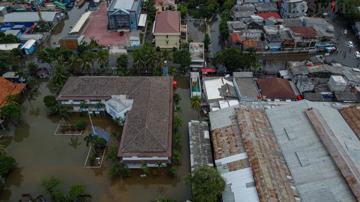 Aktivitas kendaraan dan buruh angkut kapal saat melintasi banjir rob yang melanda kawasan Pelabuhan Sunda Kelapa, Lodan Raya, Jakarta Utara, Minggu, 15 Desember 2024. (Poskota/ Ahmad Tri Hawaari)