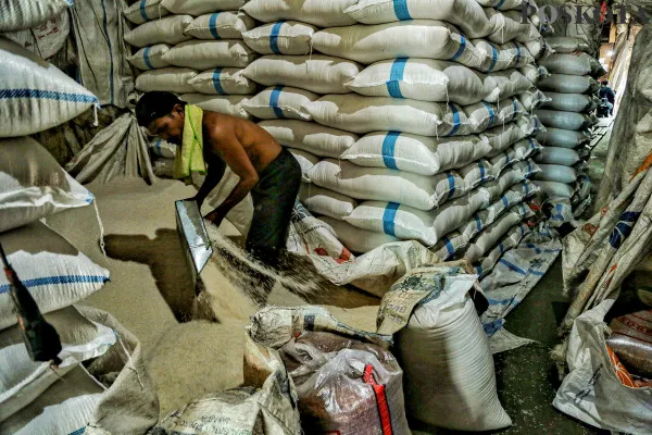 Pekerja saat memikul dan menata beras dalam karung kemasan di Pasar Induk Cipinang, Jakarta Timur, Minggu, 15 Desember 2024. (Poskota/ Ahmad Tri Hawaari)