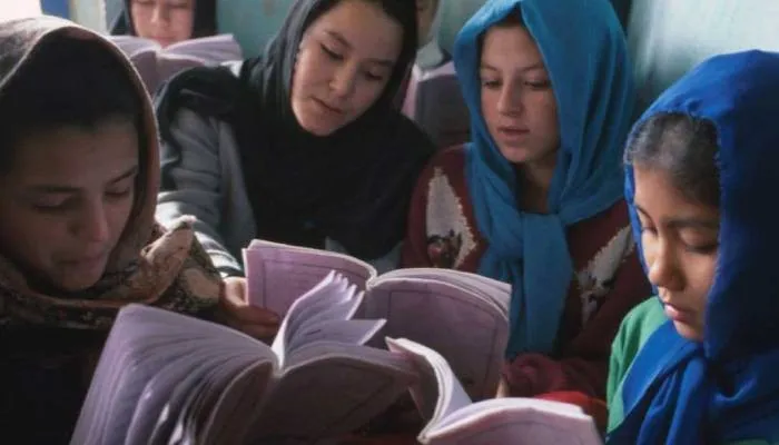 Anak perempuan Hazara membaca buku pelajaran mereka di Pusat Pendidikan Dasht-e-Barchi di Kabul Afghanistan.