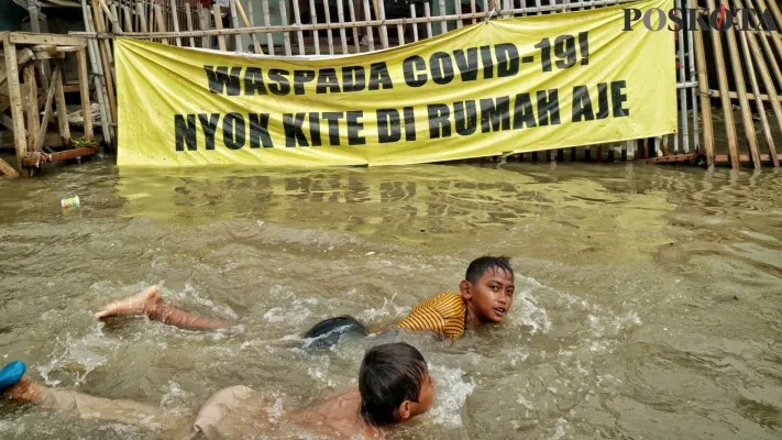 Anak-anak mandi di tengah-tengah banjir rob.(Foto: Ahmad Trihawaari)