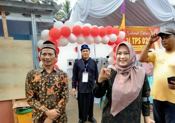 Bupati Pandeglang, Irna Narulita (kerudung), menunjukkan jarinya setelah menggunakan hak pilih di TPS 20 Kelurahan Cigadung Kecamatan Karangtanjung Kabupaten Pandeglang. (ist)