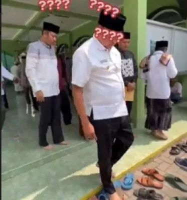 Wali Kota Bekasi Tri Adhianto saat mencari sendalnya yang hilang usai sholat di Masjid. (Ist).