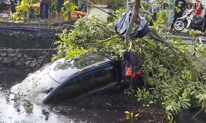 Mobil Honda Mobilio warna hitam berplat nomor B 1335 SMB terjun ke kali di Jalan Gading Batavia, Kelapa Gading, Jakarta Utara. (yono)