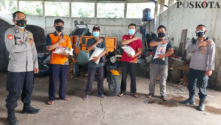 Kanit Binmas Polsek Cimanggis Iptu Rudi bersama anggota membagikan paket sembako beras kepada para pemungut sampah. (foto: angga)