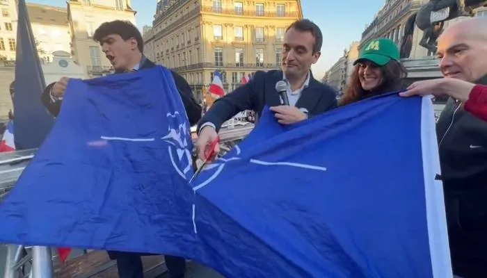 Florian Philippot merobek bendera NATO.