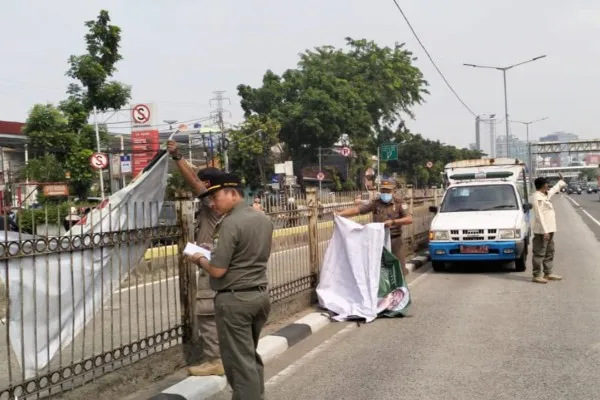 Satpol PP DKI Jakarta tertibkan ribuan bendera parpol. Foto: Ist.