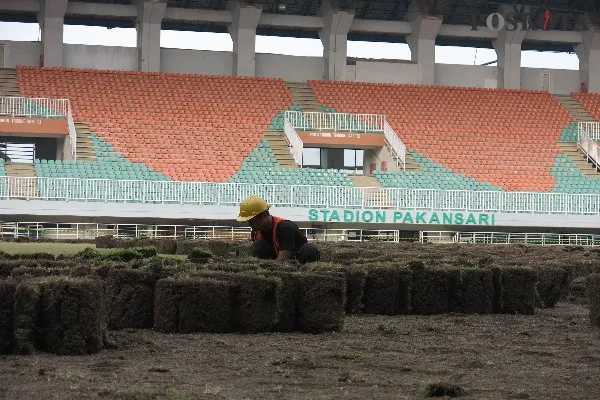 Pekerja melakukan perbaikan rumput Stadion Pakansari, Bogor. Foto: Poskota/Panca Aji.