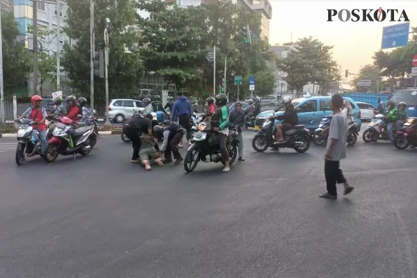 Ibu histeris lihat suami terkapar di jalanan akibat kecelakaan lalu lintas. Foto: Poskota.co.id/Pandi.