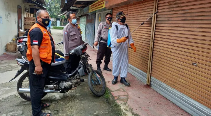 Kepala Keamanan Pokdarkamtibmas Sawangan  dan anggota Polsek Sawangan melakukan penyemprotan (angga)