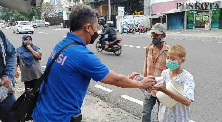 Personel Polres Jaksel membagikan takjil ke warga. (foto: poskota/novriadji wibowo)