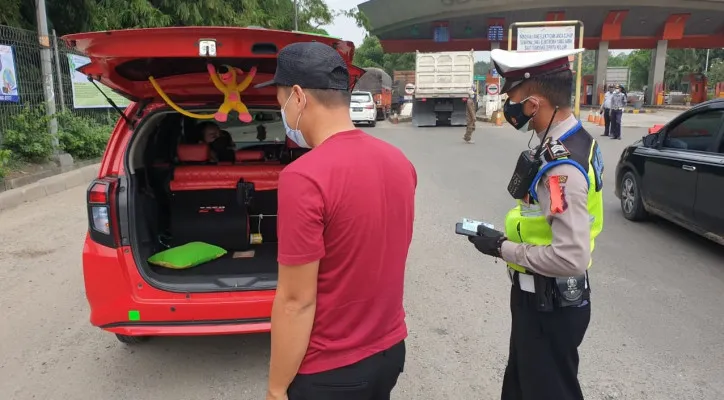 Petugas kepolisian Polresta Tangerang periksa mobil pribadi di Pos Penyekatan Gerbang Tol Cikupa, Kabupaten Tangerang, Minggu (9/5/2021). (Ridsha Vimanda)