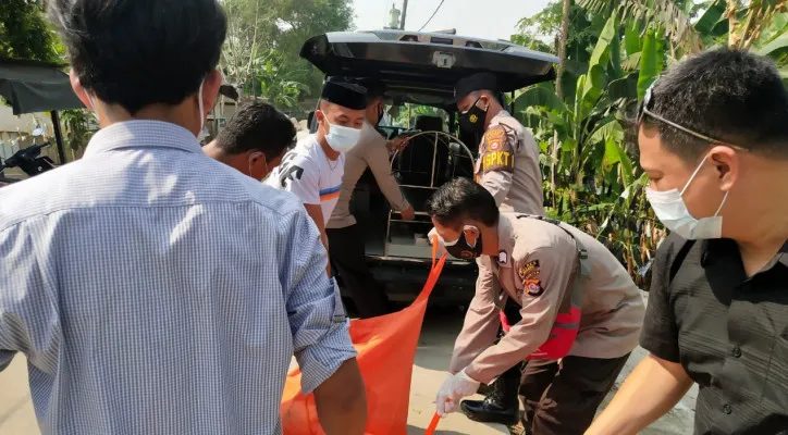 Personil polres serang saat melakukan evakuasi mayat dari sungai irigasi. (ist)