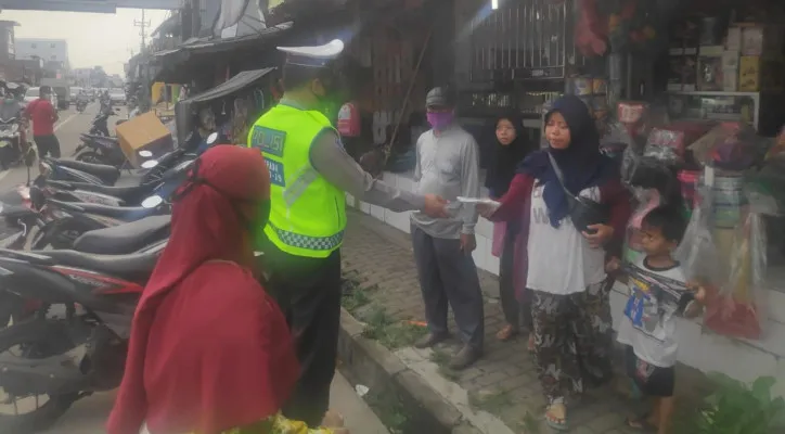 Personel Ditlantas Polda Banten membagikan masker kepada masyarakat. (foto: ist)