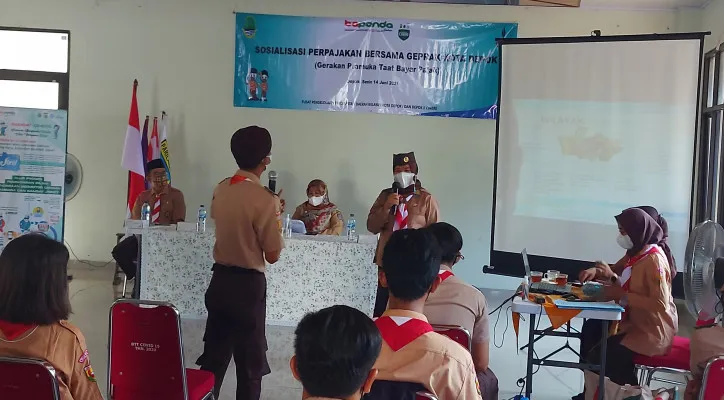 Kapus Samsat Cinere, Eni Sri Murni sedang memberikan materi sosialisasi pembayaran pajak kendaraan bermotor ke para peserta Pramuka Depok. [Foto: Poskota/Angga]