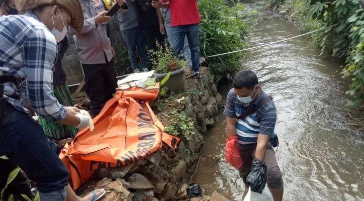 Petugas Polsek Cibinong evakuasi jasad bayi membusuk di dalam kali. (angga)