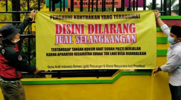 Sejumlah warga memasang spanduk penolakan atas adanya dugaan maraknya prostitusi online. (foto: iqbal)