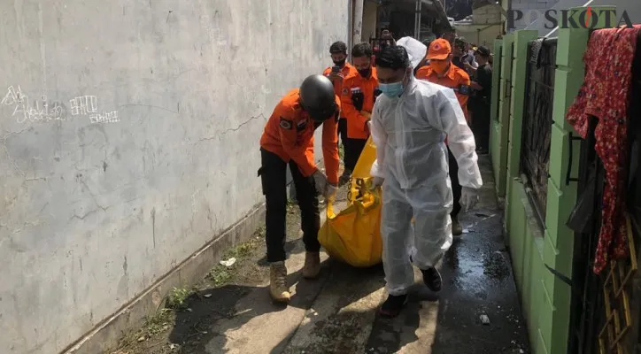 Petugas mengevakuasi jasad pemuda korban kebakaran di Kramat Jati, Jakarta Timur. (foto: mochamad ifand/poskota)