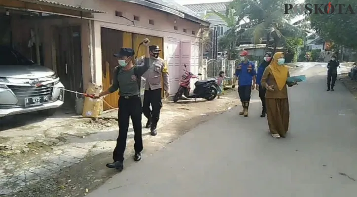 Petugas melakukan penyemprotan disinfektan di area rumah warga. (foto: yusuf permana)