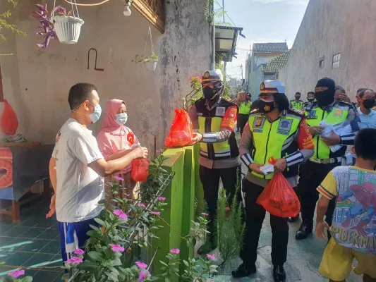 Polwan cantik Satlantas Polres Metro Depok  dipimpin Iptu Fitri membagikan paket sembako kepada warga masyarakat di Cilodong. (Angga)