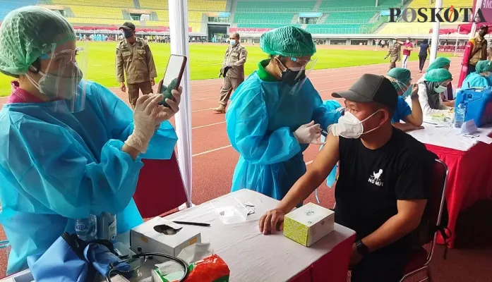 Salah satu peserta vaksinasi massal Covid-19 yang digelar Kamis (1/7/2021) di Stadion Patriot Candrabhaga Kota Bekasi (Foto/Poskota.co.id/cr02)