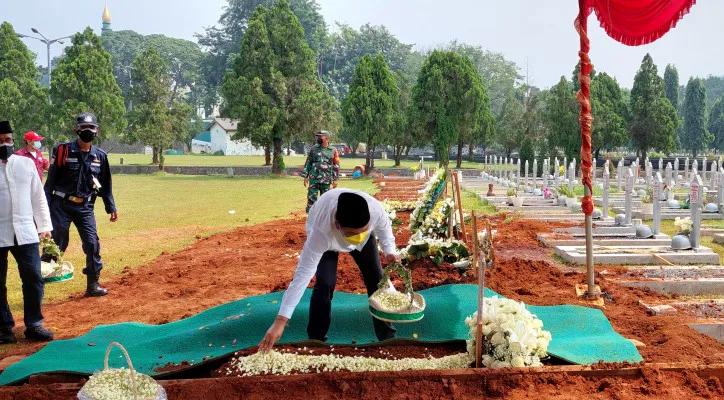 Azisoko Harmoko saat menaburkan bunga di atas kuburan sang ayah, H. Harmoko. (Foto/Poskota.co.id)