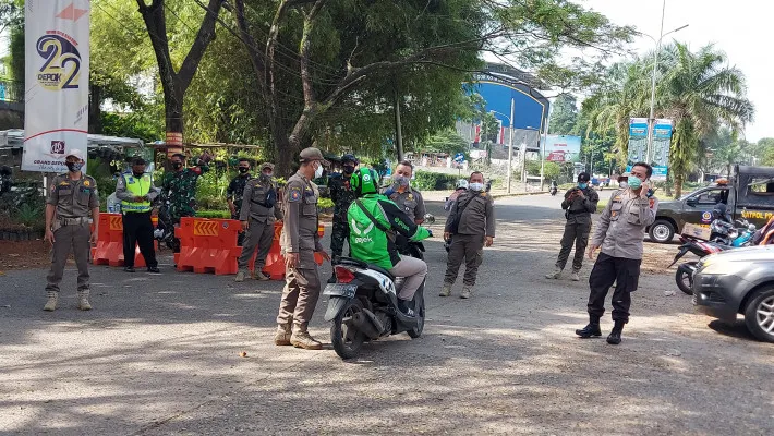 Kapolsek Sukmajaya AKP Syafri (Kaos jersy merah) bersama Camat Sukmajaya dan Wakapolsek Polsek Sukmajaya AKP Budi melakukan penyekatan bagi pengendara yang mau olahraga. (angga)