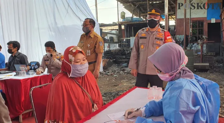 Kapolsek Sawangan AKP M Meltha Mubarak memantau vaksinasi massal slum area di pemukiman pemulung. (foto: poskota.co.id/angga pahlevi)