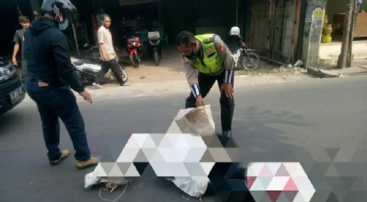 Polisi memeriksa kondisi jasad pengendara motor yang terlindas truk tronton di Jalan Raya Jatimulya, Bekasi Timur, Rabu (21/7/2021). (foto: ist0