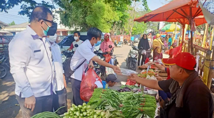 Petugas Disperdagin saat memberikan masker ke pedagang dan pengunjung di Pasar Kranggot, Kecamatan Jombang, Kota Cilegon, Rabu (21/7/2021). (foto: ist)