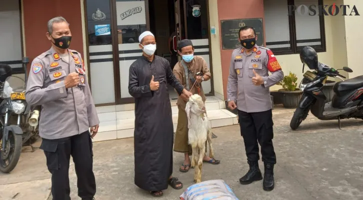 Kapolsek Bojonggede AKP Dwi Susanto dengan Kanit Binmas AKP Sugiyanto menyerahkan kambing dan sembako paket beras kepada pemilik Pondok Pesantren di Polsek Bojonggede. (Foto/Poskota.co.id/Angga)