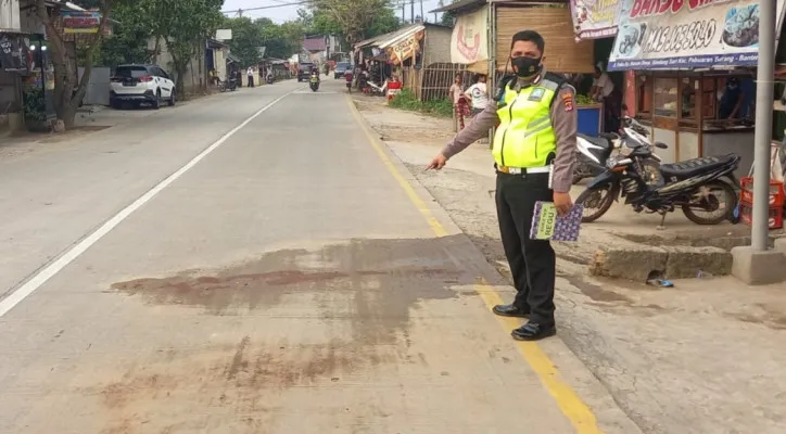 Petugas unit lakalantas saat menunjukan lokasi terjadinya kecelakaan. (ist)