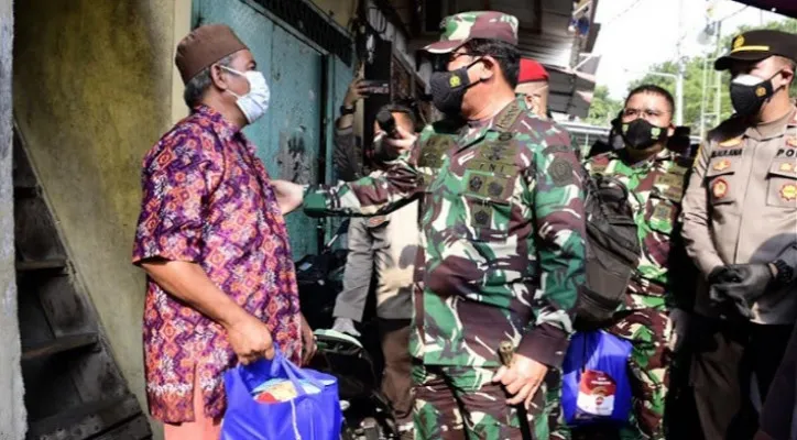 Panglima TNI Marsekal Hadi Tjahjanto saat memberikan bantuan beras kepada warga di Jakarta. (foto: uspenTNI)