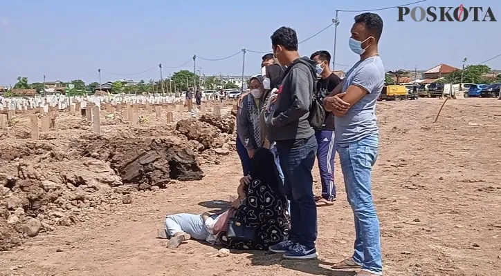 Tangis haru sang anak pecah di tengah pemakaman Covid-19 di TPU Rorotan. (Foto/Poskota.co.id/Yono)