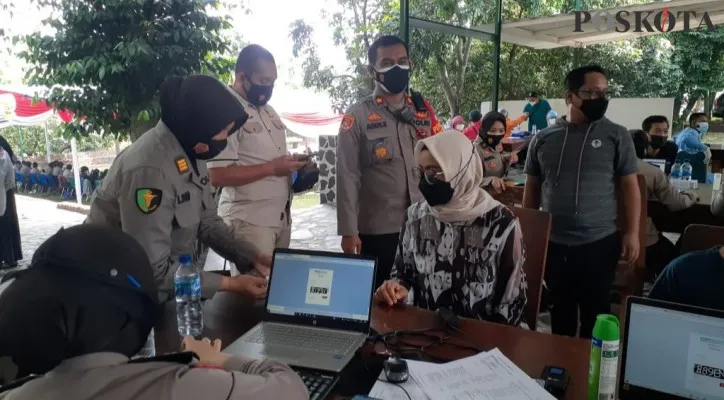 Kapolsek Beji Kompol Agus Khaeron mengamankan jalannya vaksinasi masal di gerai vaksin presisi Polsek Beji. (Foto/Poskota.co.id/Angga)