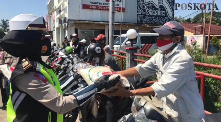 Wakasat Lantas Polres Metro Depok Kompol Sugeng didampingi Kanit Kamsel AKP Elly mem bagikan paket sembako ke tukang ojek Pangkalan Cilangkap. (Foto/Poskota.co.id/Angga)