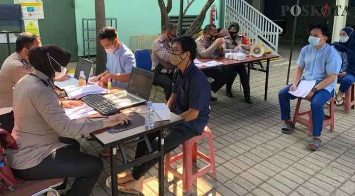 Wakapolsek Cimanggis, AKP Sulani didampingi Kanit Kamsel Satlantas Polres Metro Depok, AKP Elly bersama anggota membuka gerai vaksin keliling di PT Immortal. (foto: poskota.co.id/angga pahlevi)