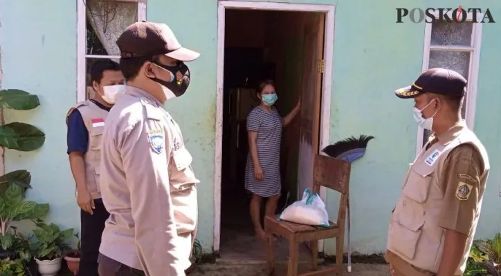 Anggota Polsek Beji membagikan sembako kepada warga membutuhkan dan sedang menjalankan Isoman di rumah. (Foto/Poskota.co.id/Angga)