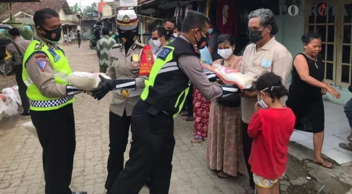 Anggota Kamsel Satlantas Polres Metro Depok melakukan penyemprotan dan bagikan paket sembako ke rumah warga Kampung tuna netra. (angga) 