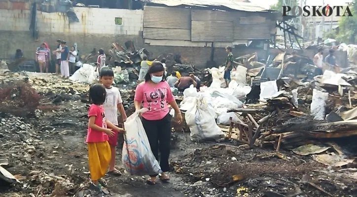 Warga korban kebakaran di Jalan Prof. Muhammad Yamin, Gang Pinang RT 04/05 Kelurahan Duren Jaya, Kecamatan Bekasi Timur sedang memungut barang-barang yang masih bisa diselamatkan, Minggu (1/8/2021) (Foto/Poskota.co.id/CR02)