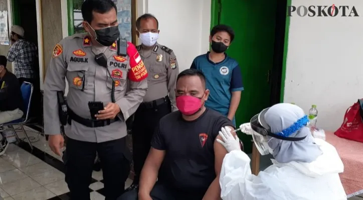 Kapolsek Beji Kompol Agus Khaeron melihat warga yang divaksin di vaksin merdeka. (Foto/Poskota.co.id/Angga)