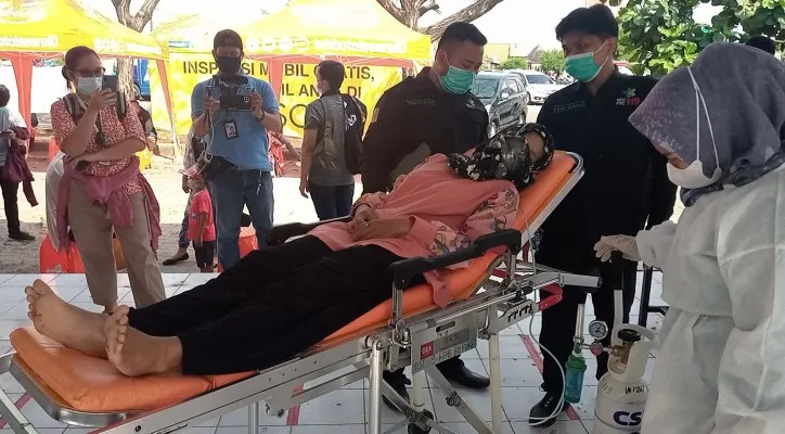 Desy Ratnasari (21) saat dievakuasi oleh petugas Dinas Kesehatan Kabupaten Bekasi lantaran pingsan setelah divaksinasi di area Parkir Lotte Mart, Jalan Kampung Pilar, Cikarang Kota, Cikarang Utara, Kabupaten Bekasi, Minggu (08/08/2021). (foto: ist)