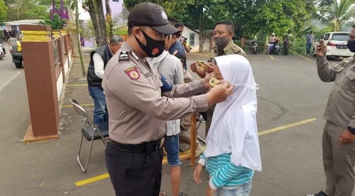 Anggota gabungan Polsek Rancabungur menegur dan membagikan masker kepada warga yang tidak ber masker di Jalan (Foto/Humas Polres Bogor)